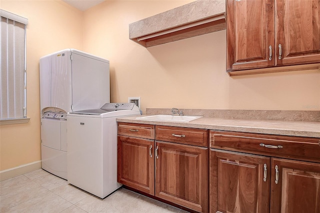 clothes washing area featuring sink, cabinets, washing machine and clothes dryer, and light tile patterned flooring