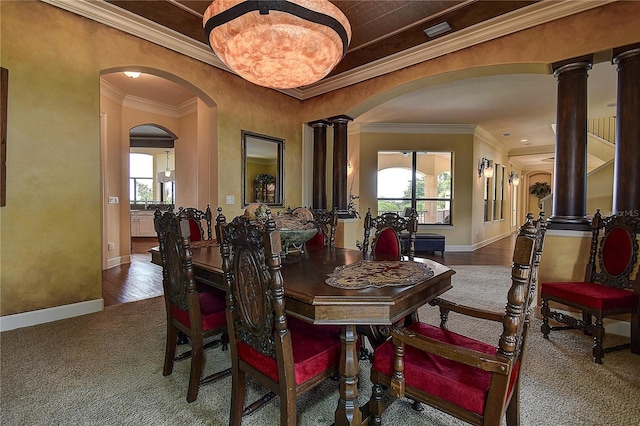 dining room with ornate columns, crown molding, and carpet floors