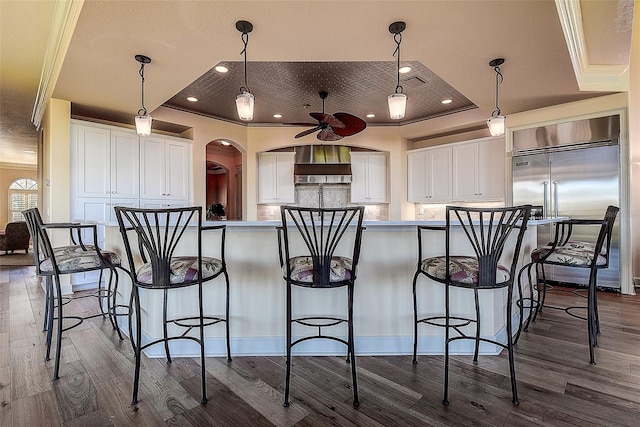 kitchen with white cabinetry, decorative light fixtures, and a raised ceiling