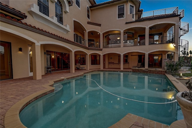 view of swimming pool with ceiling fan and a patio area