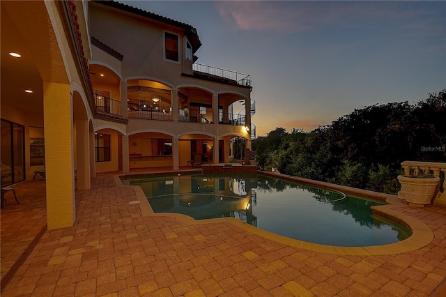 pool at dusk with a patio