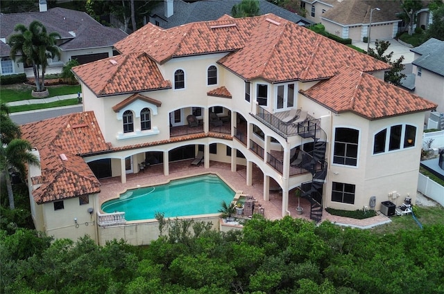 rear view of house with a patio, central AC, a tiled roof, a fenced in pool, and stucco siding