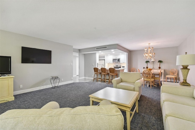 living room with a chandelier and dark carpet