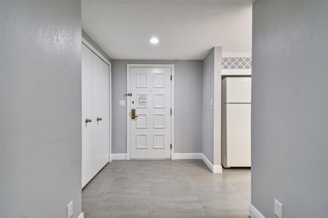 tiled entryway featuring a textured ceiling