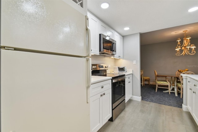 kitchen featuring a chandelier, light tile floors, decorative light fixtures, appliances with stainless steel finishes, and white cabinets