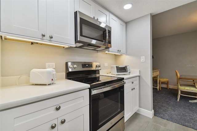 kitchen with white cabinetry, light colored carpet, and appliances with stainless steel finishes