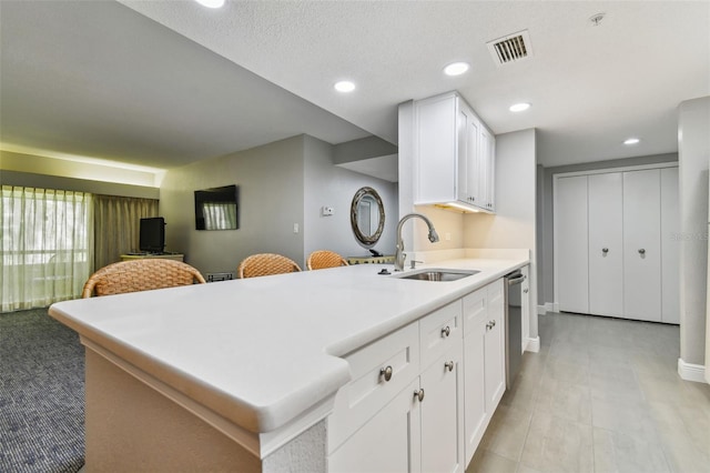 kitchen with light tile flooring, white cabinets, sink, and dishwasher