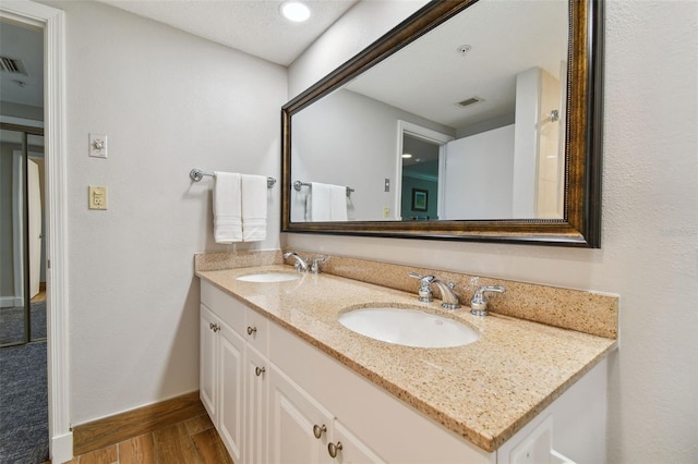 bathroom featuring large vanity, hardwood / wood-style floors, and dual sinks