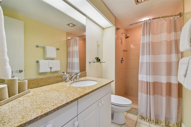 bathroom featuring toilet, vanity with extensive cabinet space, and tile floors