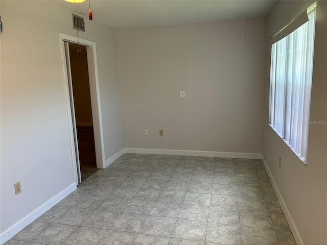 empty room with baseboards and visible vents