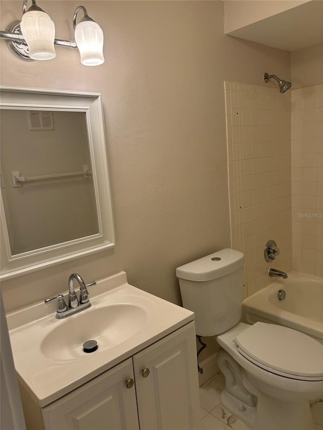 full bathroom with toilet, tiled shower / bath combo, vanity, and tile patterned flooring