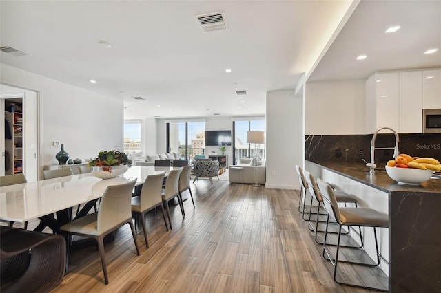 dining room with sink and light hardwood / wood-style flooring