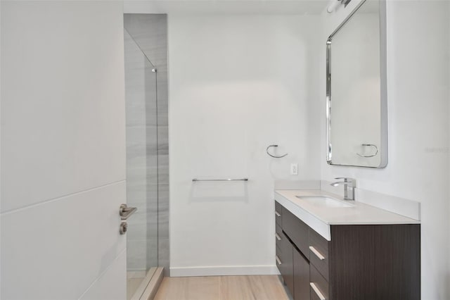 bathroom featuring a shower with door, hardwood / wood-style floors, and vanity