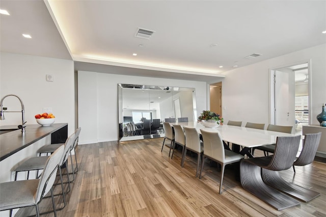 dining room featuring light wood-type flooring and sink