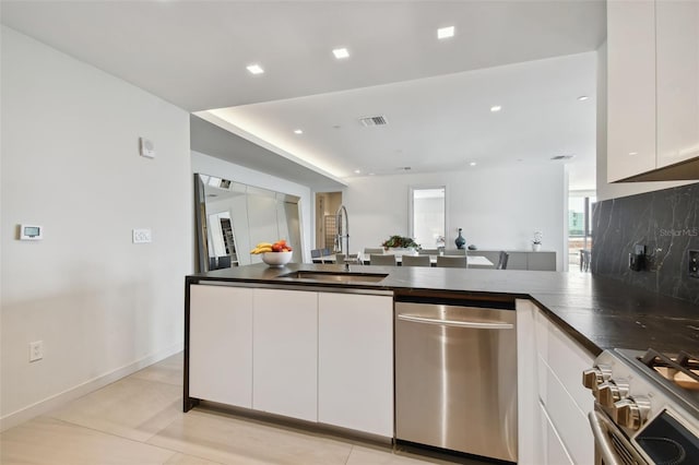 kitchen featuring light tile flooring, stainless steel appliances, white cabinetry, and sink