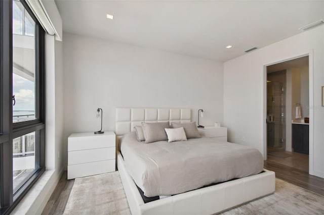 bedroom with light hardwood / wood-style floors and multiple windows