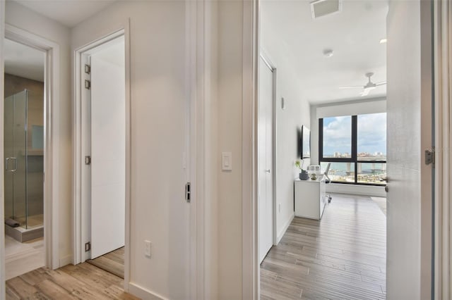 corridor with light hardwood / wood-style floors