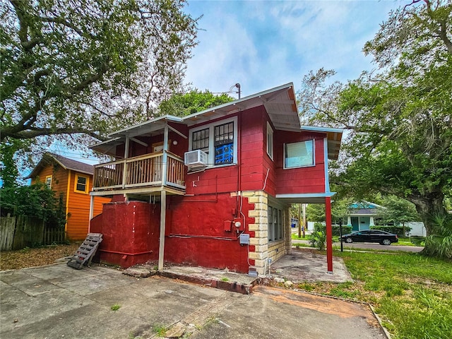 view of front of home featuring cooling unit and a balcony