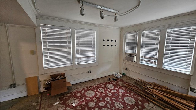 empty room featuring cooling unit, crown molding, and rail lighting