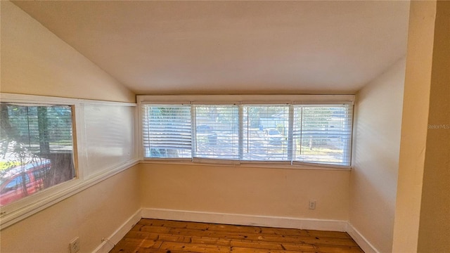 unfurnished room with hardwood / wood-style flooring and vaulted ceiling