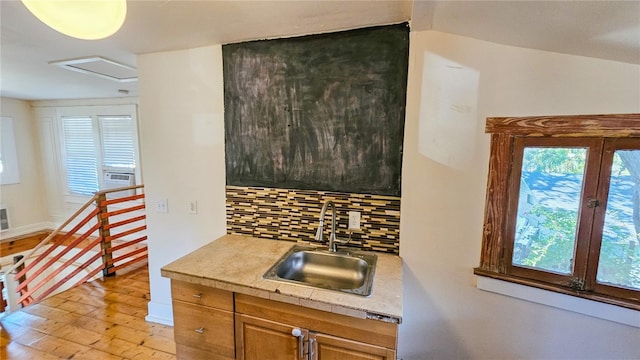 kitchen with sink, backsplash, and light hardwood / wood-style floors