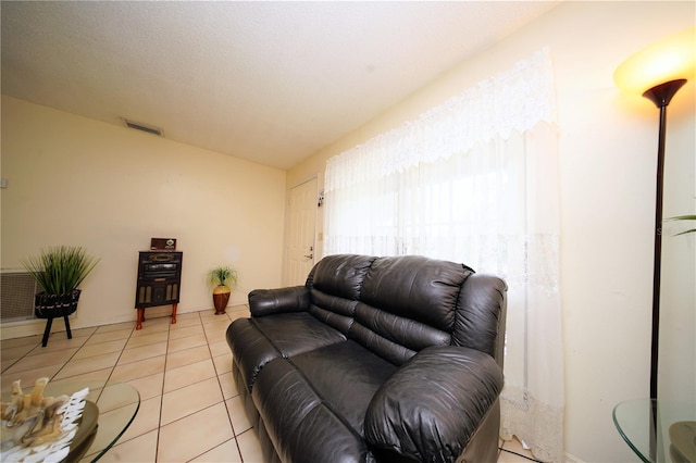 living room with a textured ceiling and light tile floors