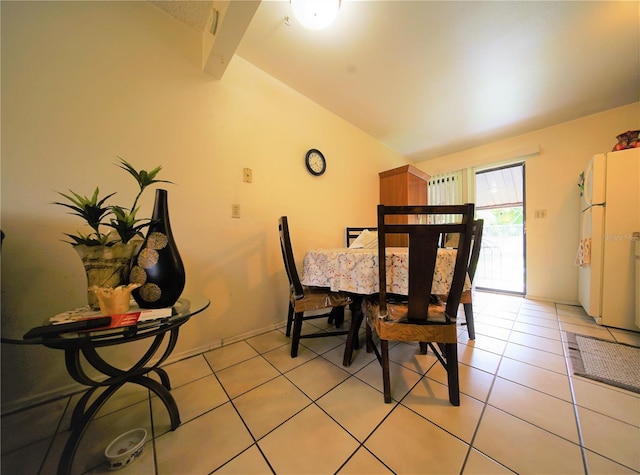 dining area featuring lofted ceiling with beams and tile floors