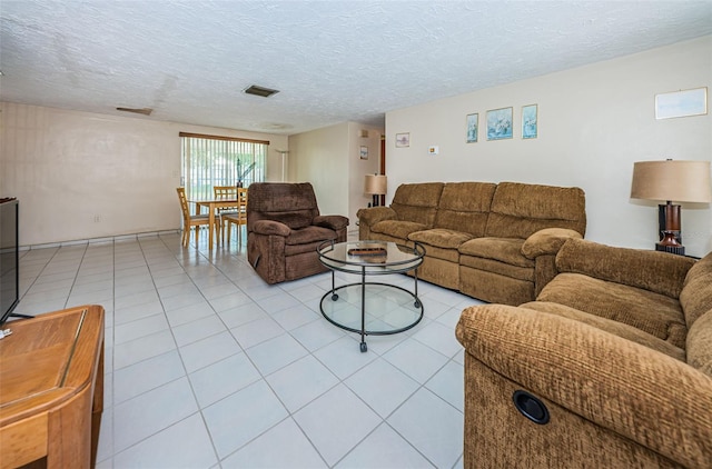 living room with light tile flooring and a textured ceiling