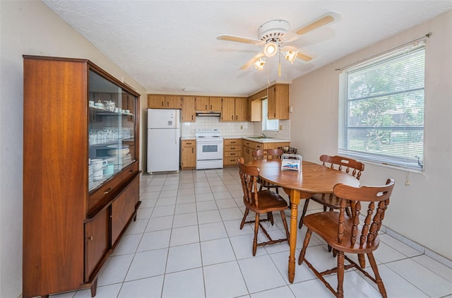 tiled dining room with ceiling fan and sink