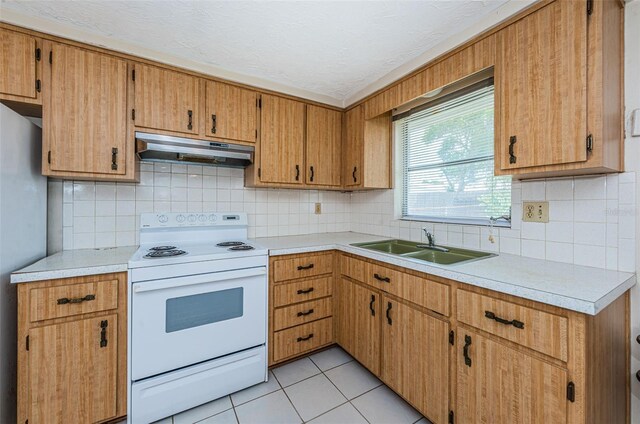 kitchen featuring light tile floors, white range with electric cooktop, stainless steel fridge, backsplash, and sink