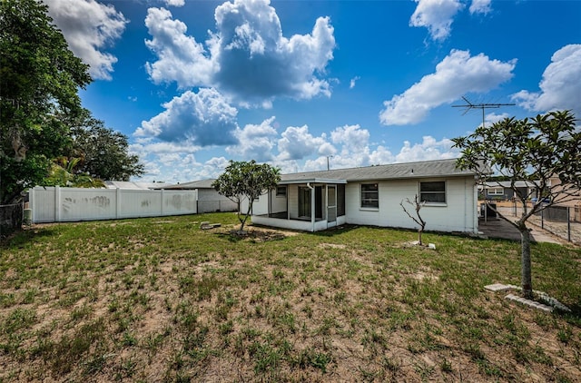 rear view of house featuring a yard