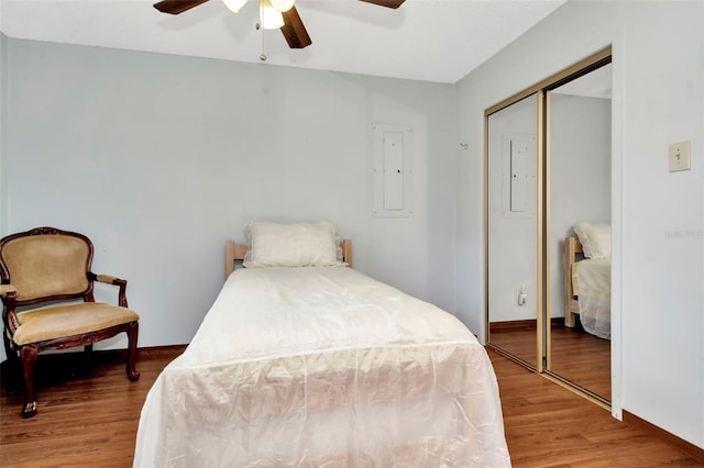 bedroom with a closet, electric panel, ceiling fan, and hardwood / wood-style floors