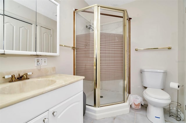 bathroom with a shower with shower door, vanity, toilet, and tile patterned floors