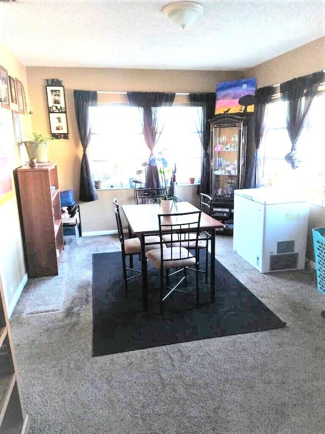 dining room with dark carpet and a textured ceiling