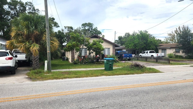 view of front facade with a front lawn and fence