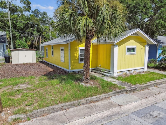 view of front of property featuring a storage shed