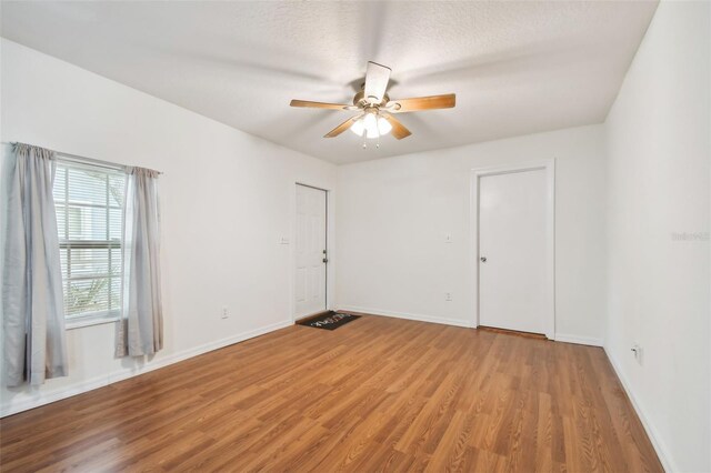 empty room featuring ceiling fan and hardwood / wood-style floors