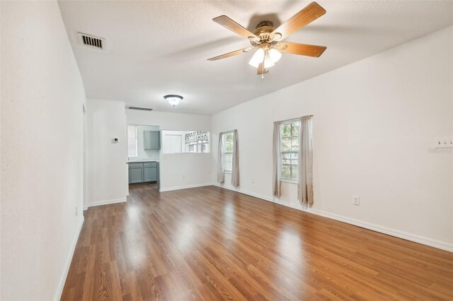 unfurnished living room with hardwood / wood-style flooring and ceiling fan