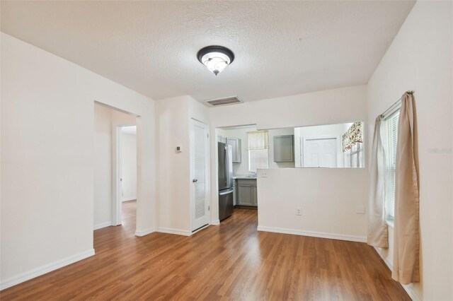 unfurnished room featuring a textured ceiling and wood-type flooring