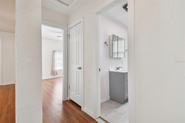 hall with sink and light wood-type flooring