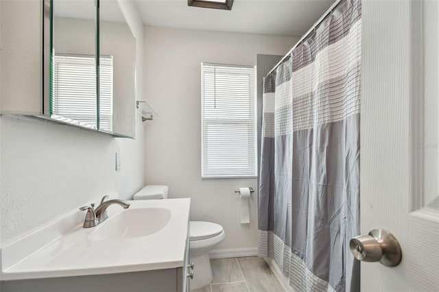 bathroom with vanity, tile patterned flooring, toilet, and a healthy amount of sunlight