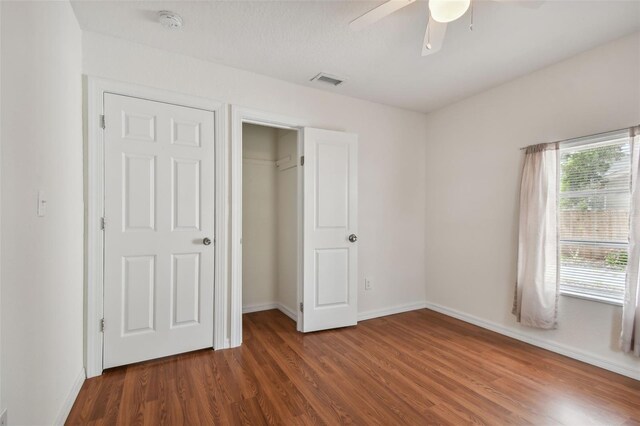 unfurnished bedroom with a closet, hardwood / wood-style flooring, and ceiling fan