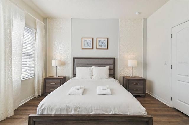 bedroom with dark hardwood / wood-style flooring and multiple windows