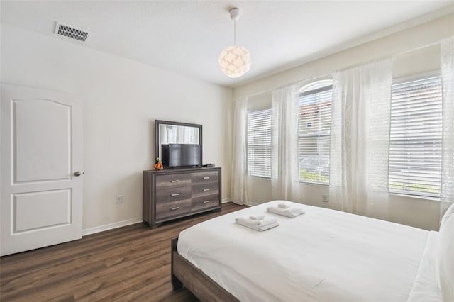 bedroom with dark hardwood / wood-style floors