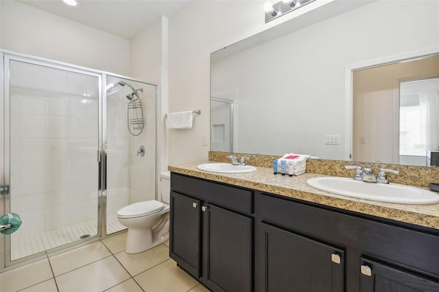 bathroom with tile patterned floors, toilet, a shower with door, and vanity