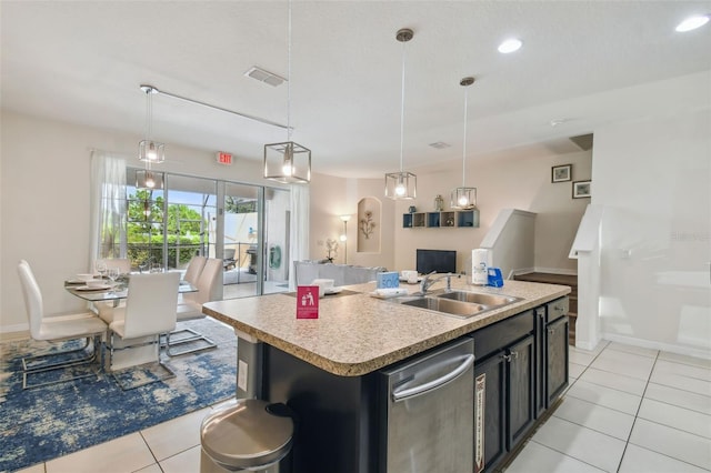 kitchen with decorative light fixtures, a kitchen island with sink, stainless steel dishwasher, sink, and light tile patterned flooring