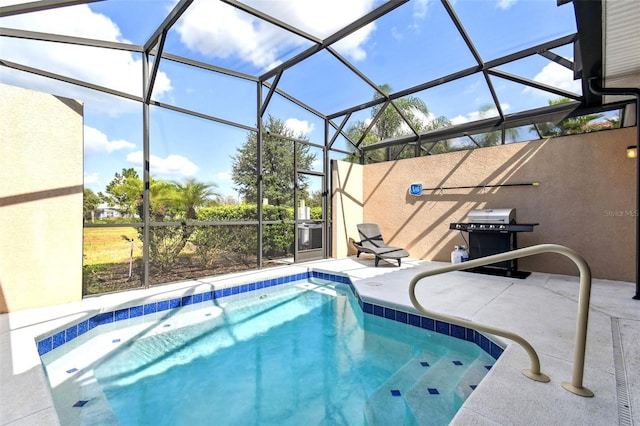 view of pool with a patio area, glass enclosure, and area for grilling