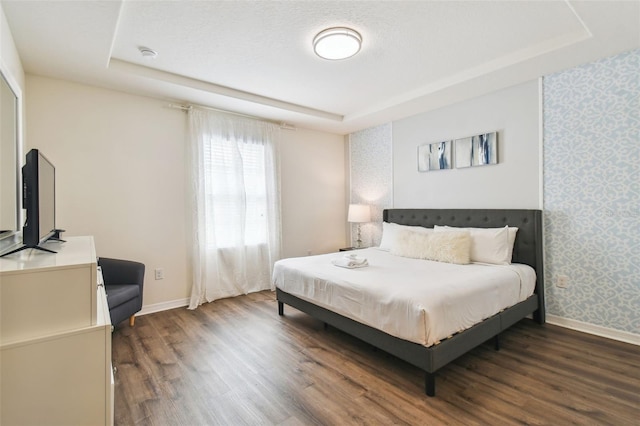 bedroom featuring dark hardwood / wood-style floors and a raised ceiling