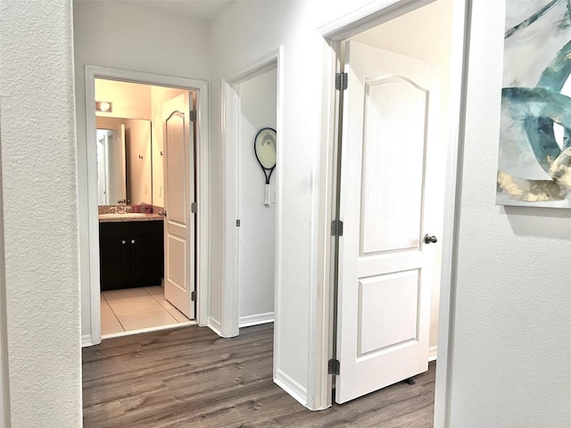 hall with hardwood / wood-style flooring and sink