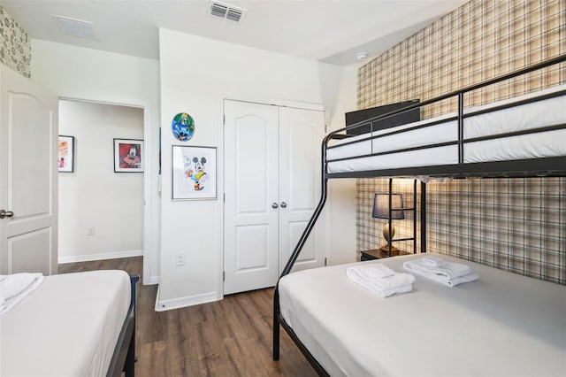 bedroom with a closet and dark hardwood / wood-style flooring